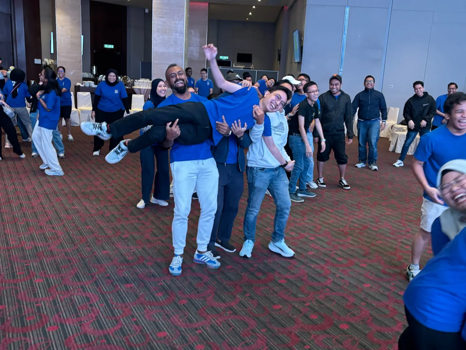Tetra Exponus team energised, lifting a colleague during a group activity