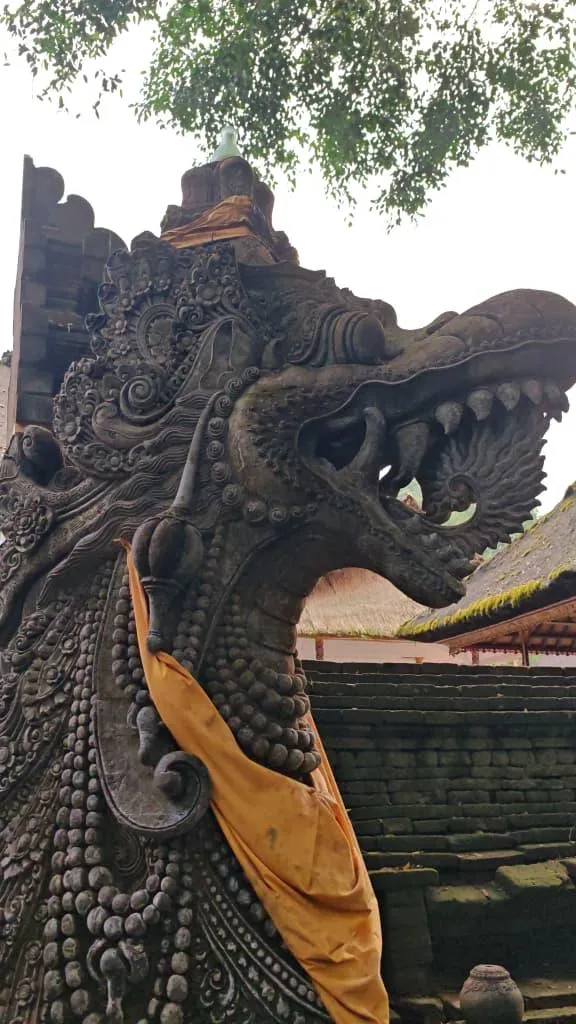 Close-up of an ornately carved stone dragon (naga) guardian statue at a Balinese temple